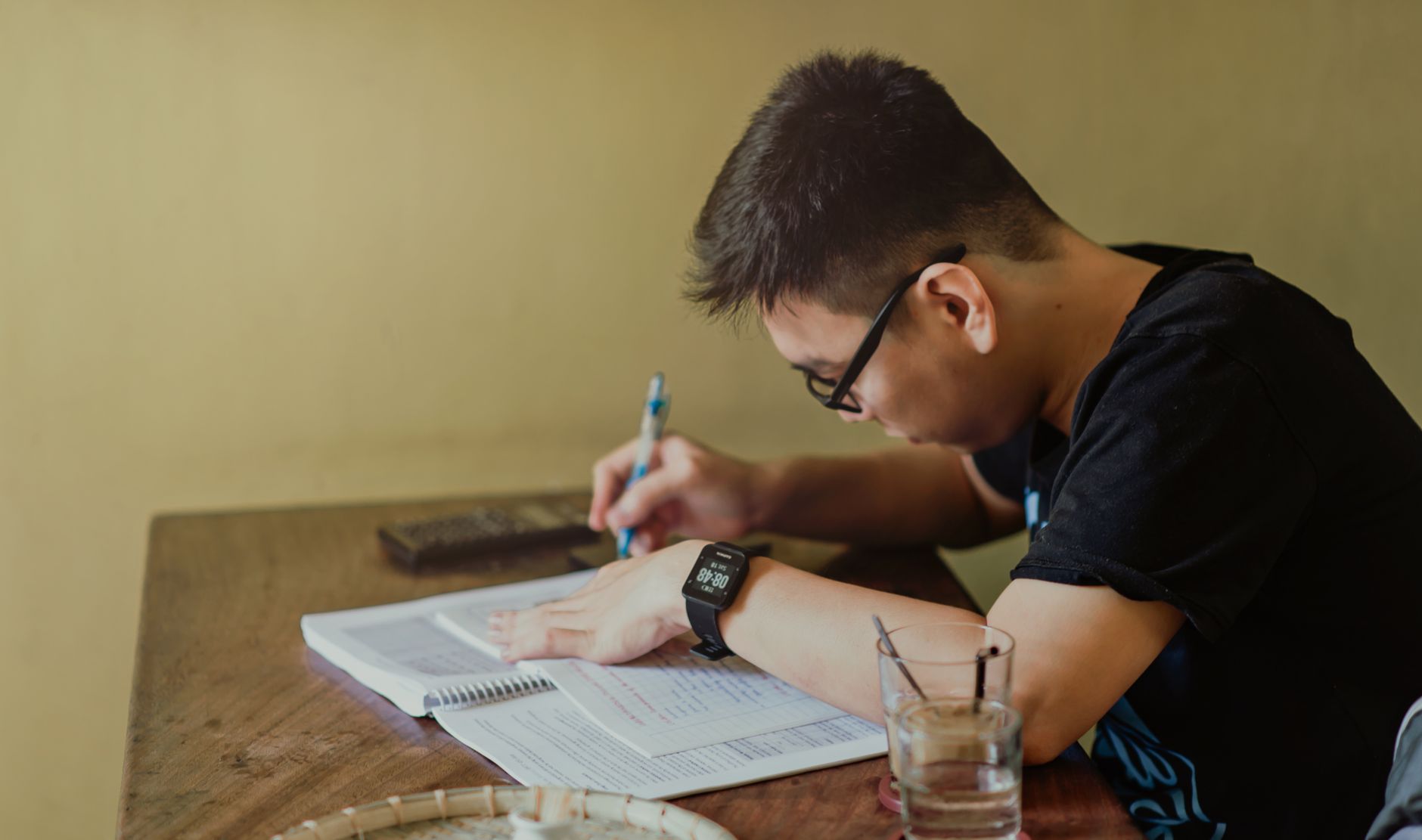 A student concentrating on notes at a desk