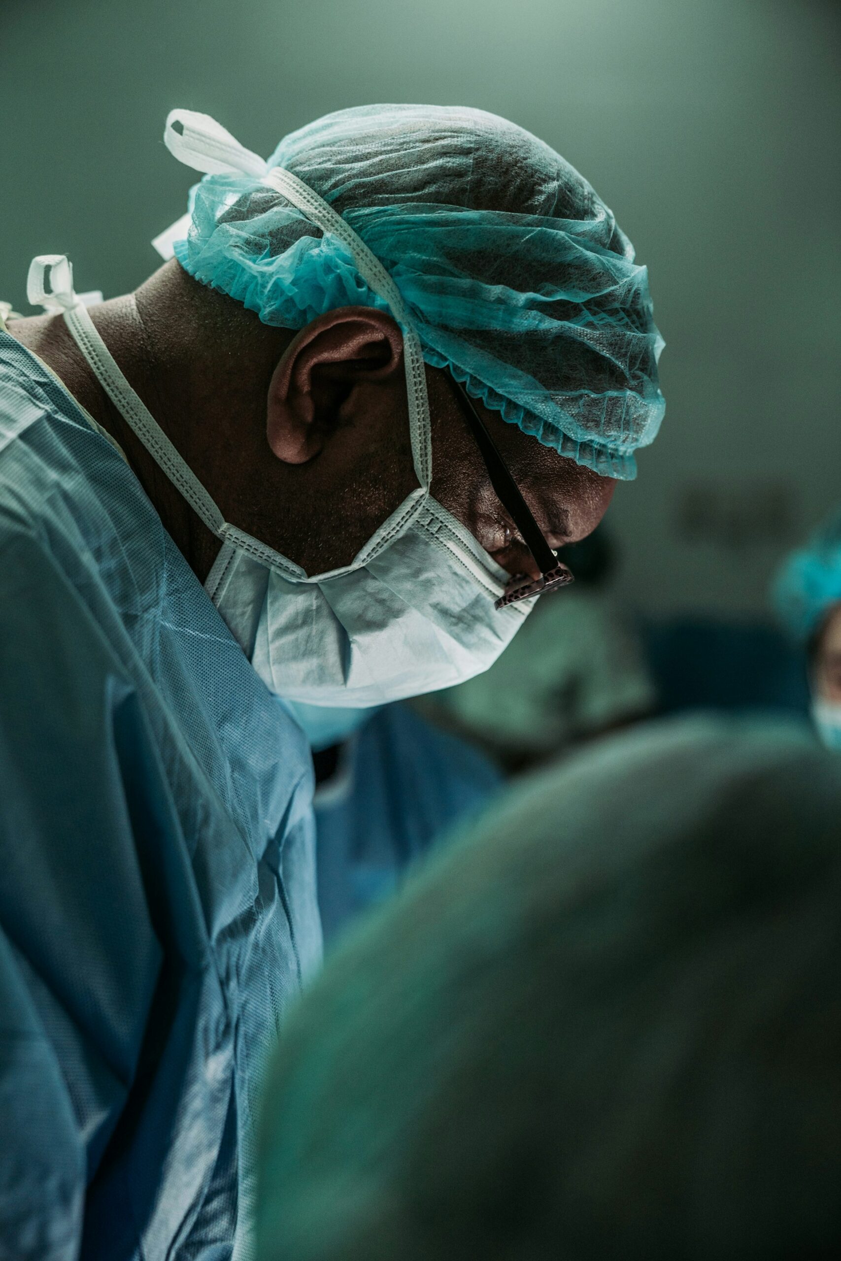 A surgeon in cap and mask concentrating during a procedure