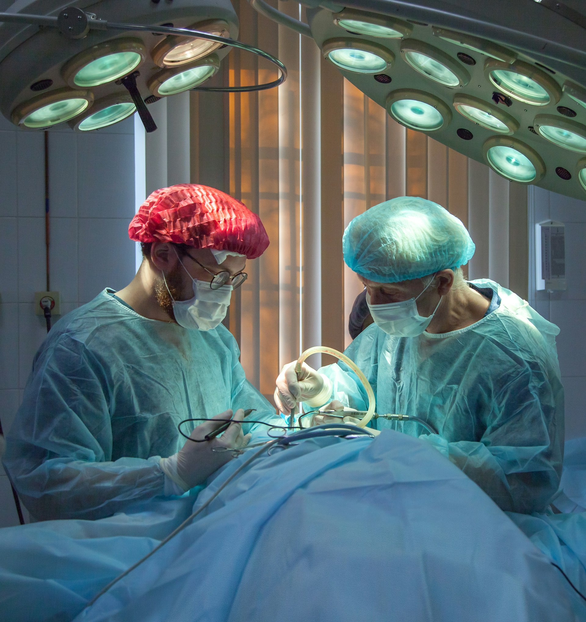 Two surgeons working under operating theatre lights