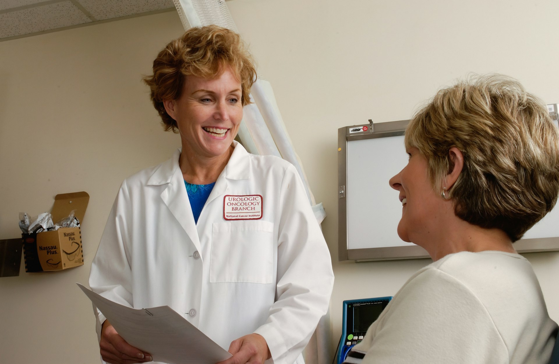 A clinician in a white coat talking with a patient