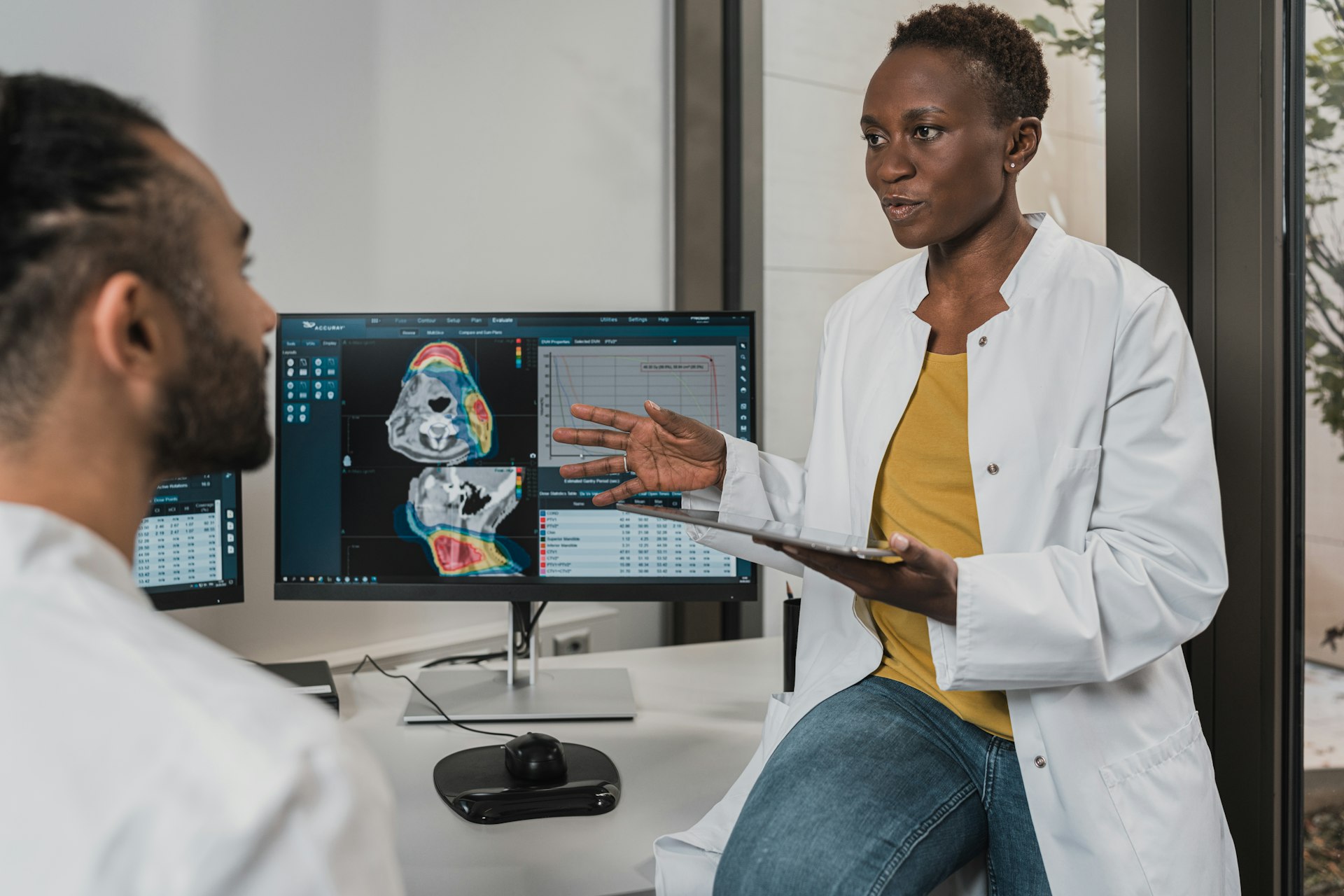 Two clinicians discussing medical imaging on a monitor